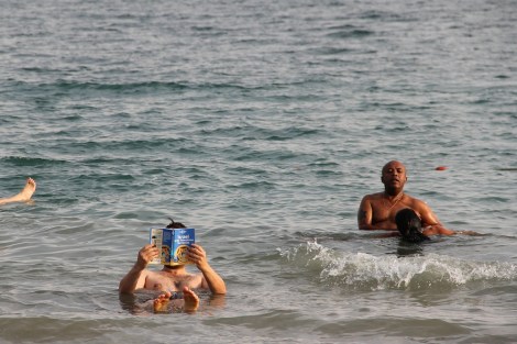 reading the guide book while floating in the Dead Sea